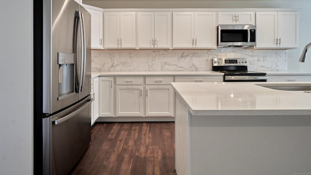 kitchen featuring stainless steel appliances, tasteful backsplash, dark wood-style flooring, and a sink