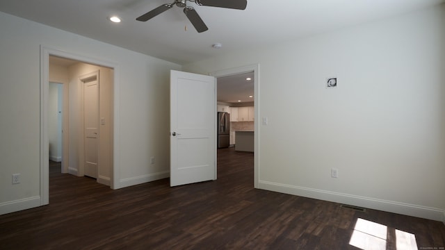 unfurnished bedroom featuring recessed lighting, dark wood-style flooring, visible vents, baseboards, and stainless steel refrigerator with ice dispenser