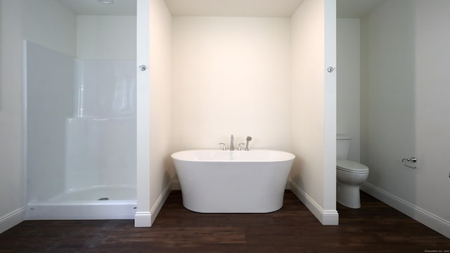 full bath featuring a shower, toilet, wood finished floors, a freestanding tub, and baseboards