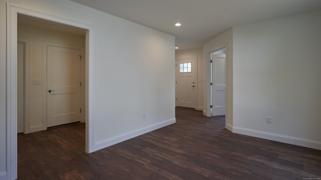 unfurnished room featuring baseboards, dark wood-style flooring, and recessed lighting