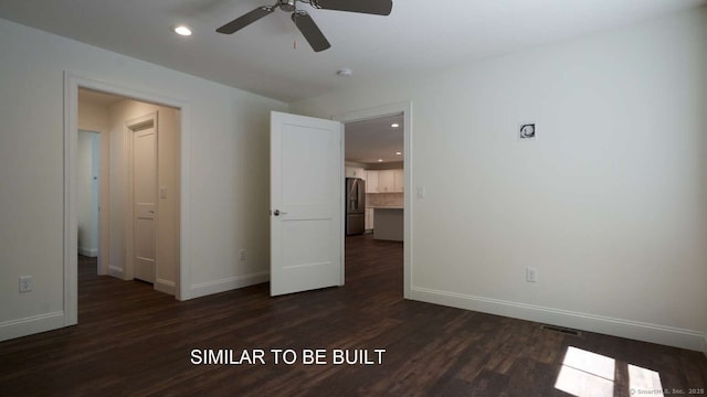 spare room with dark wood-type flooring and ceiling fan