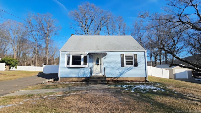 cape cod home with a front lawn