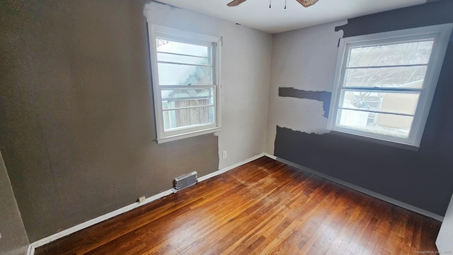 empty room with hardwood / wood-style floors, a healthy amount of sunlight, and ceiling fan