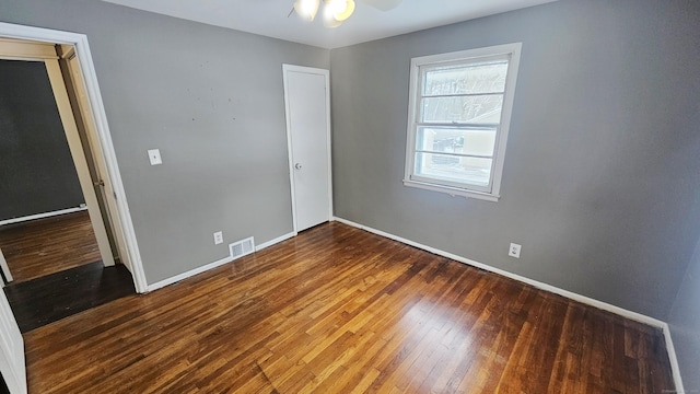 spare room featuring dark hardwood / wood-style floors and ceiling fan