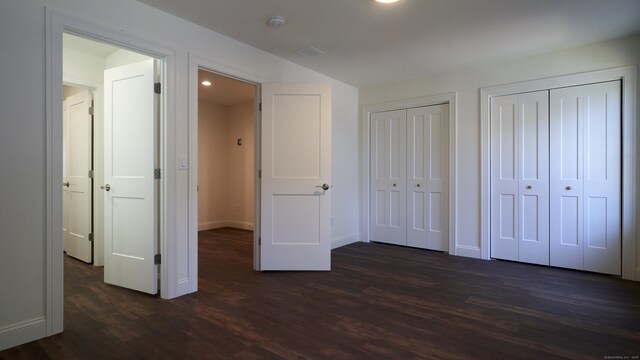 16 Jordan Ln, Colchester, CT 06415 - unfurnished bedroom featuring dark wood-style floors, recessed lighting, baseboards, and multiple closets