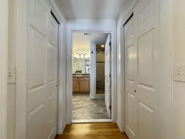 corridor featuring sink and light wood-type flooring