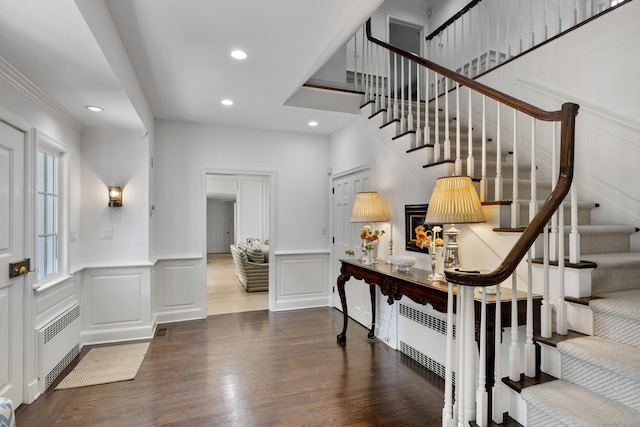 entryway featuring crown molding, dark wood-type flooring, and radiator heating unit