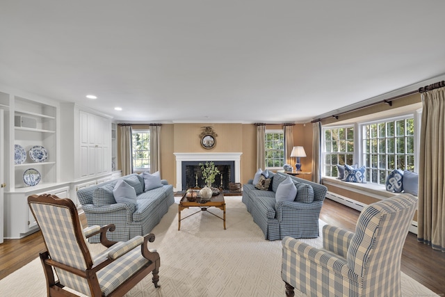 living room with a baseboard radiator, built in features, and light wood-type flooring