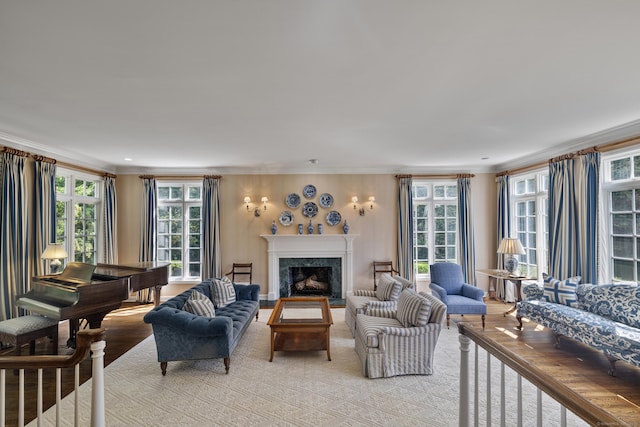 living room featuring ornamental molding, a fireplace, and light wood-type flooring