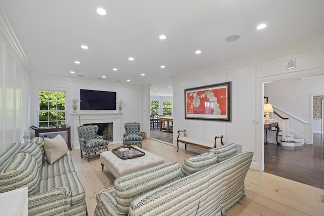 living room featuring crown molding and light hardwood / wood-style flooring