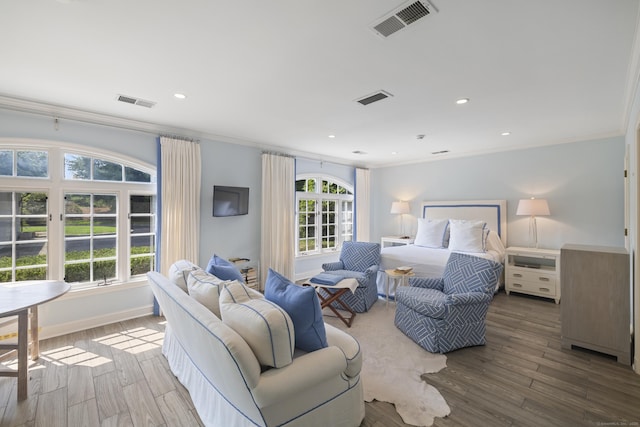 bedroom featuring multiple windows, hardwood / wood-style floors, and crown molding