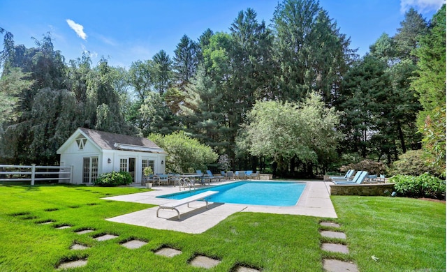 view of pool with an outdoor structure, a diving board, a patio, and a lawn