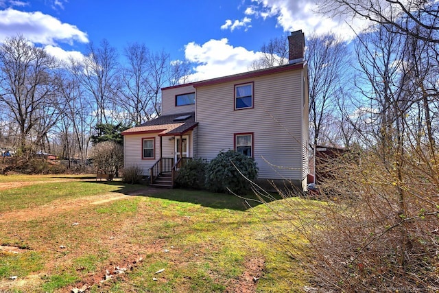 rear view of house featuring a lawn