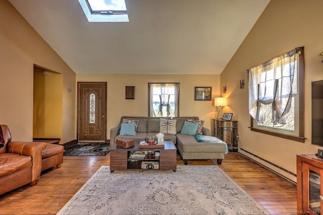 living room with light hardwood / wood-style flooring, a baseboard radiator, lofted ceiling with skylight, and plenty of natural light