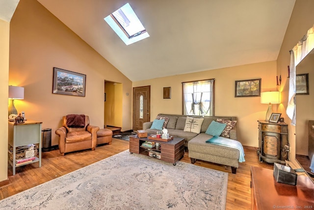 living room with lofted ceiling with skylight and light hardwood / wood-style flooring