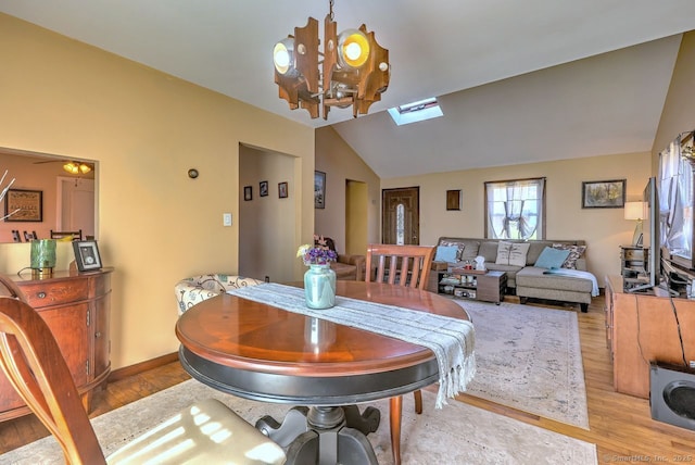 dining area featuring lofted ceiling, an inviting chandelier, and light wood-type flooring