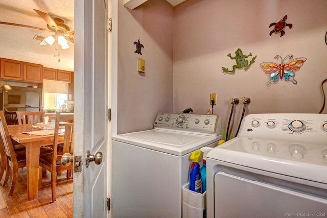 laundry room featuring washer and clothes dryer, light hardwood / wood-style floors, and ceiling fan