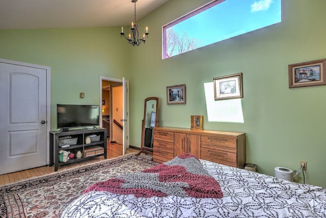 bedroom featuring wood-type flooring, high vaulted ceiling, and an inviting chandelier