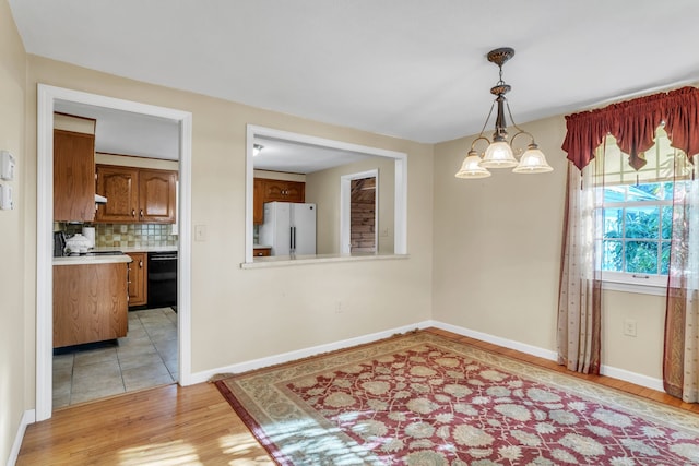 dining space featuring an inviting chandelier and light hardwood / wood-style flooring