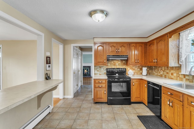 kitchen featuring baseboard heating, backsplash, sink, and black appliances