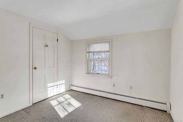 carpeted spare room with lofted ceiling and a baseboard heating unit