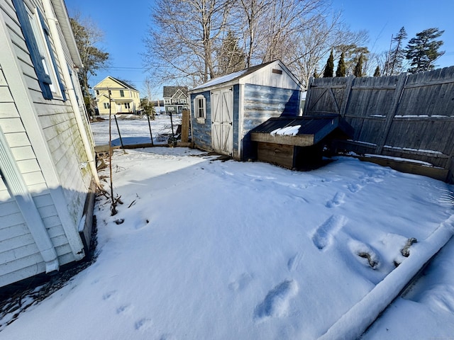 yard covered in snow featuring a shed