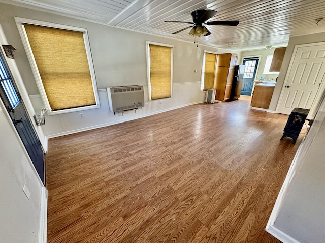 unfurnished living room with heating unit, hardwood / wood-style flooring, wooden ceiling, and ceiling fan