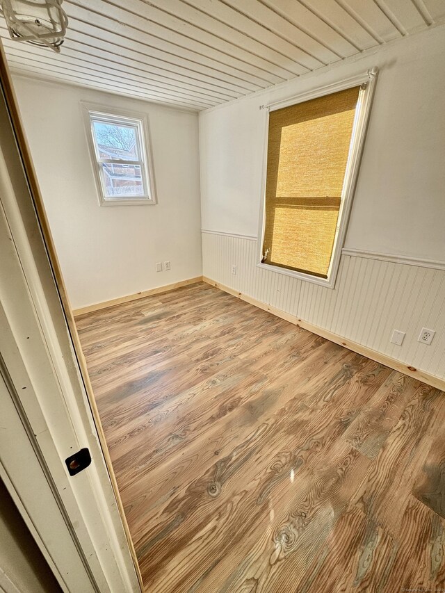 unfurnished room with wood ceiling and hardwood / wood-style flooring