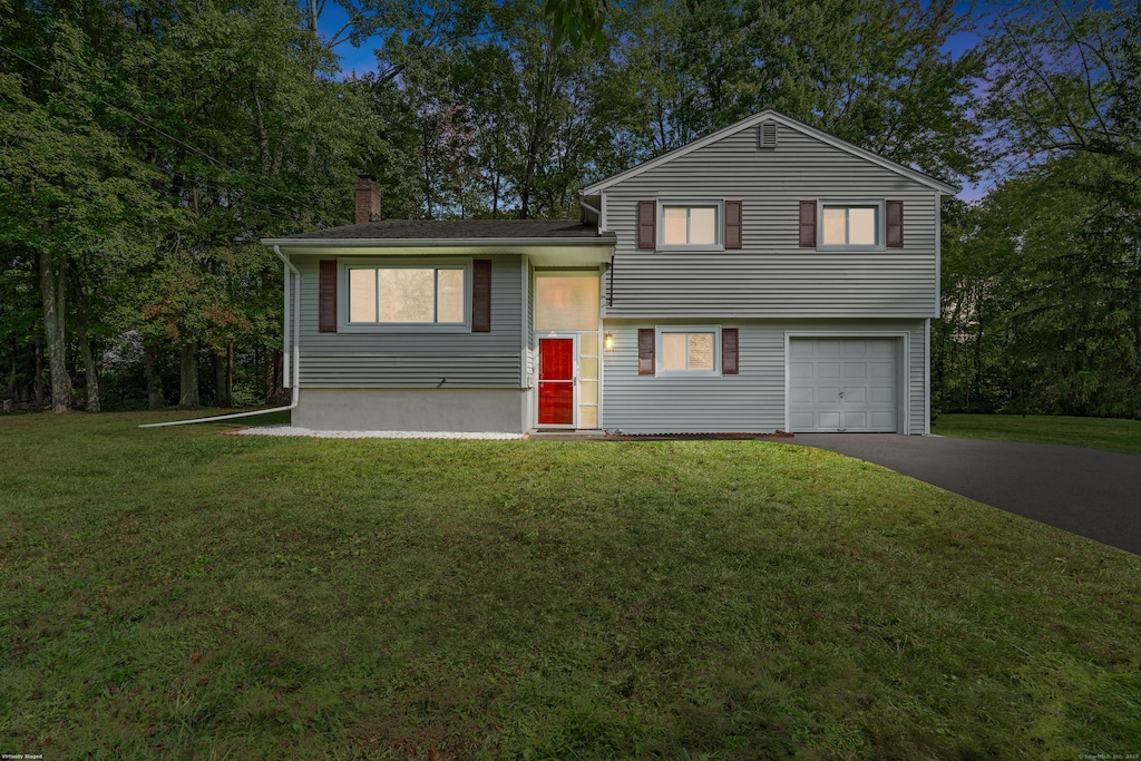 tri-level home featuring a garage and a front yard