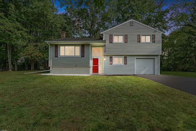 tri-level home featuring a garage and a front yard