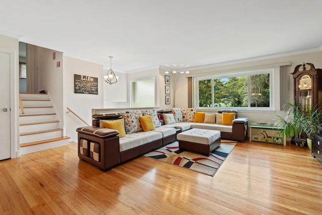 living room featuring ornamental molding, a chandelier, and light hardwood / wood-style flooring