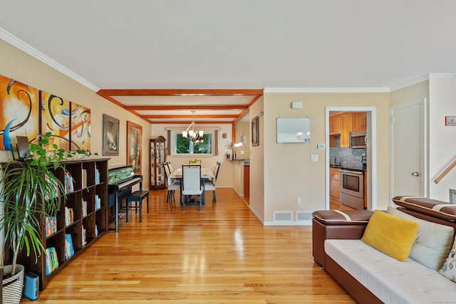 living room with beamed ceiling, ornamental molding, an inviting chandelier, and light hardwood / wood-style floors