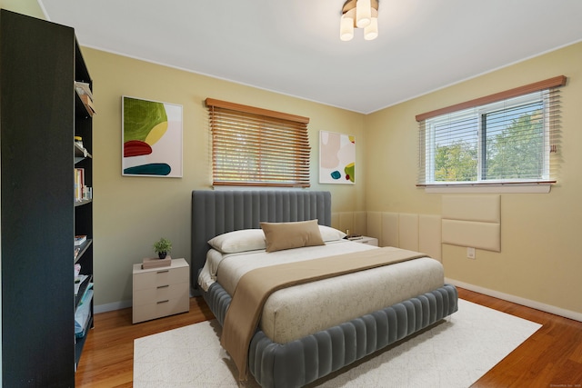 bedroom featuring radiator heating unit and hardwood / wood-style floors