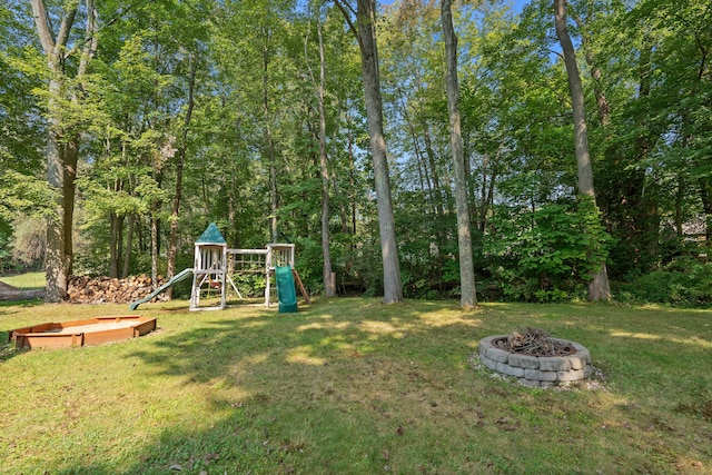 view of yard featuring a playground and an outdoor fire pit