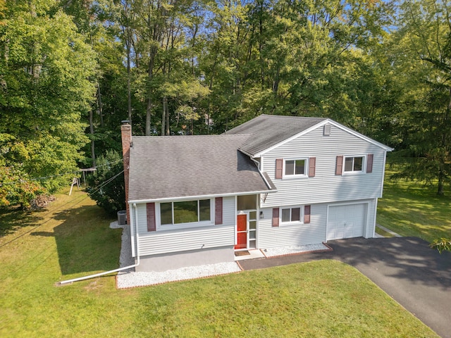 tri-level home with central AC, a garage, and a front yard