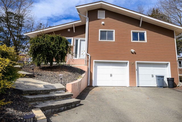 view of side of property with aphalt driveway and an attached garage