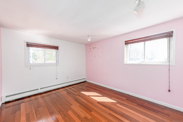 unfurnished room featuring hardwood / wood-style flooring, baseboards, and a baseboard radiator