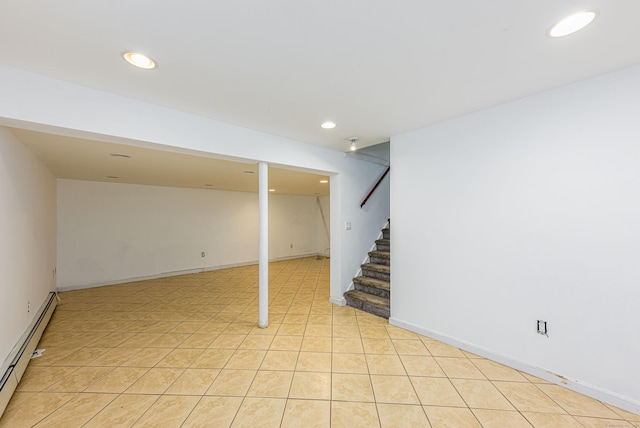 finished below grade area featuring light tile patterned flooring, baseboard heating, recessed lighting, and stairs