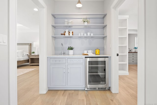 bar with sink, wine cooler, and light hardwood / wood-style floors