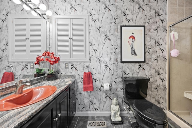 bathroom with a shower with door, vanity, tile patterned floors, and toilet