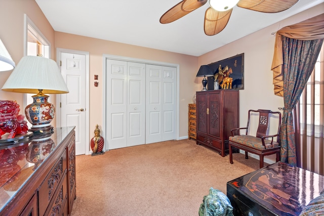 sitting room with ceiling fan, light colored carpet, and a healthy amount of sunlight