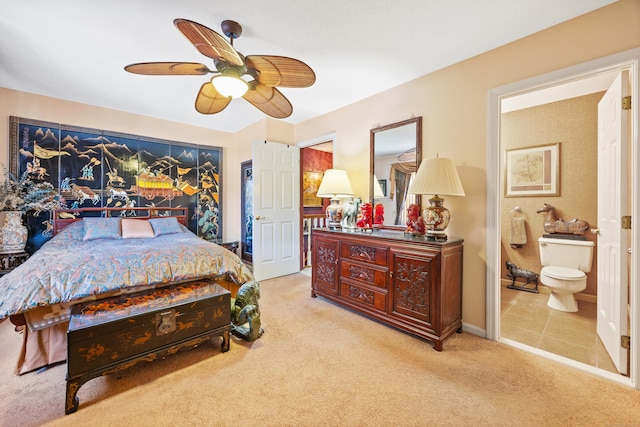 bedroom featuring ceiling fan, light colored carpet, and connected bathroom