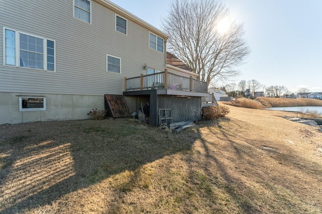 rear view of property with a wooden deck and a lawn