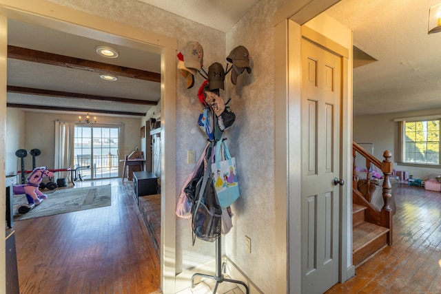 hallway featuring an inviting chandelier, beam ceiling, and wood-type flooring