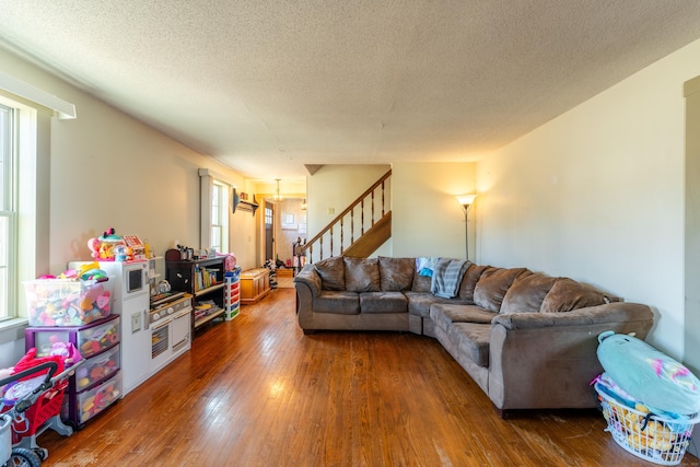 living room featuring dark wood-type flooring and a textured ceiling