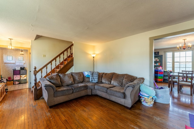 living room featuring a notable chandelier, hardwood / wood-style floors, and a textured ceiling