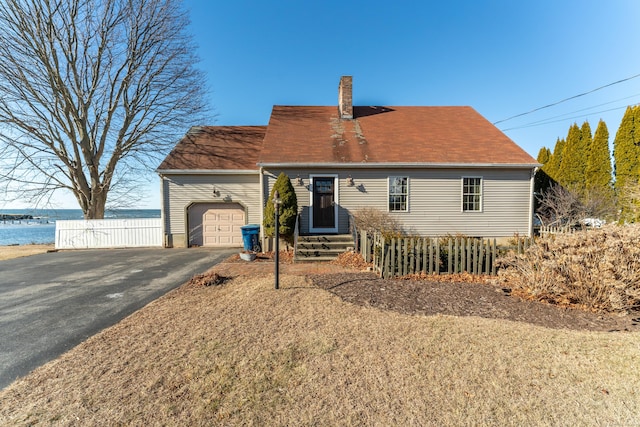 view of front of house with a garage and a water view