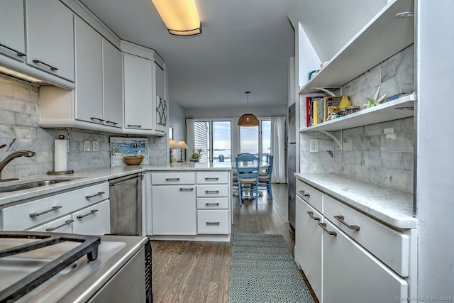 kitchen with sink, dishwasher, pendant lighting, decorative backsplash, and white cabinets