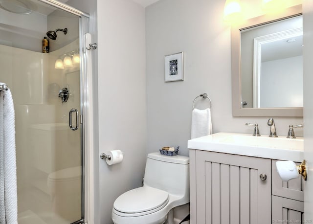 bathroom with vanity, toilet, and a shower with door