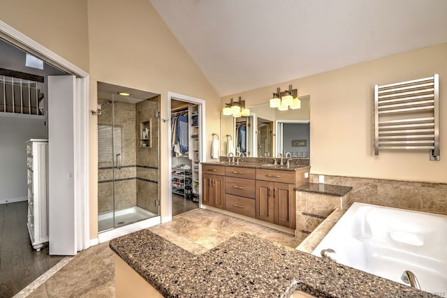 bathroom featuring separate shower and tub, vanity, radiator, and high vaulted ceiling